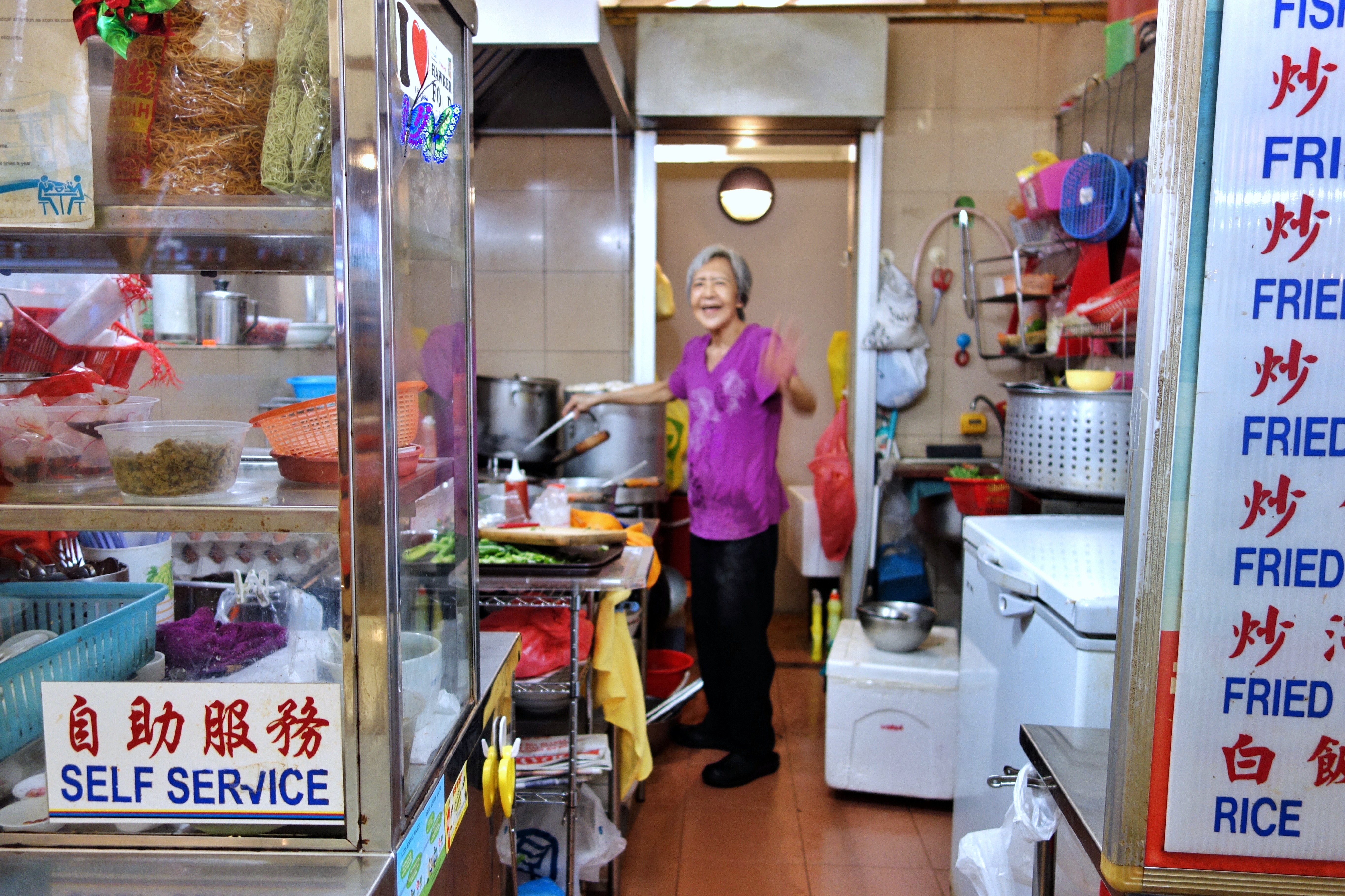 Hawker selling hor fun, fish porridge, and other Singaporean food at a hawker centre at Holland Village | ShopkeeperStories.com